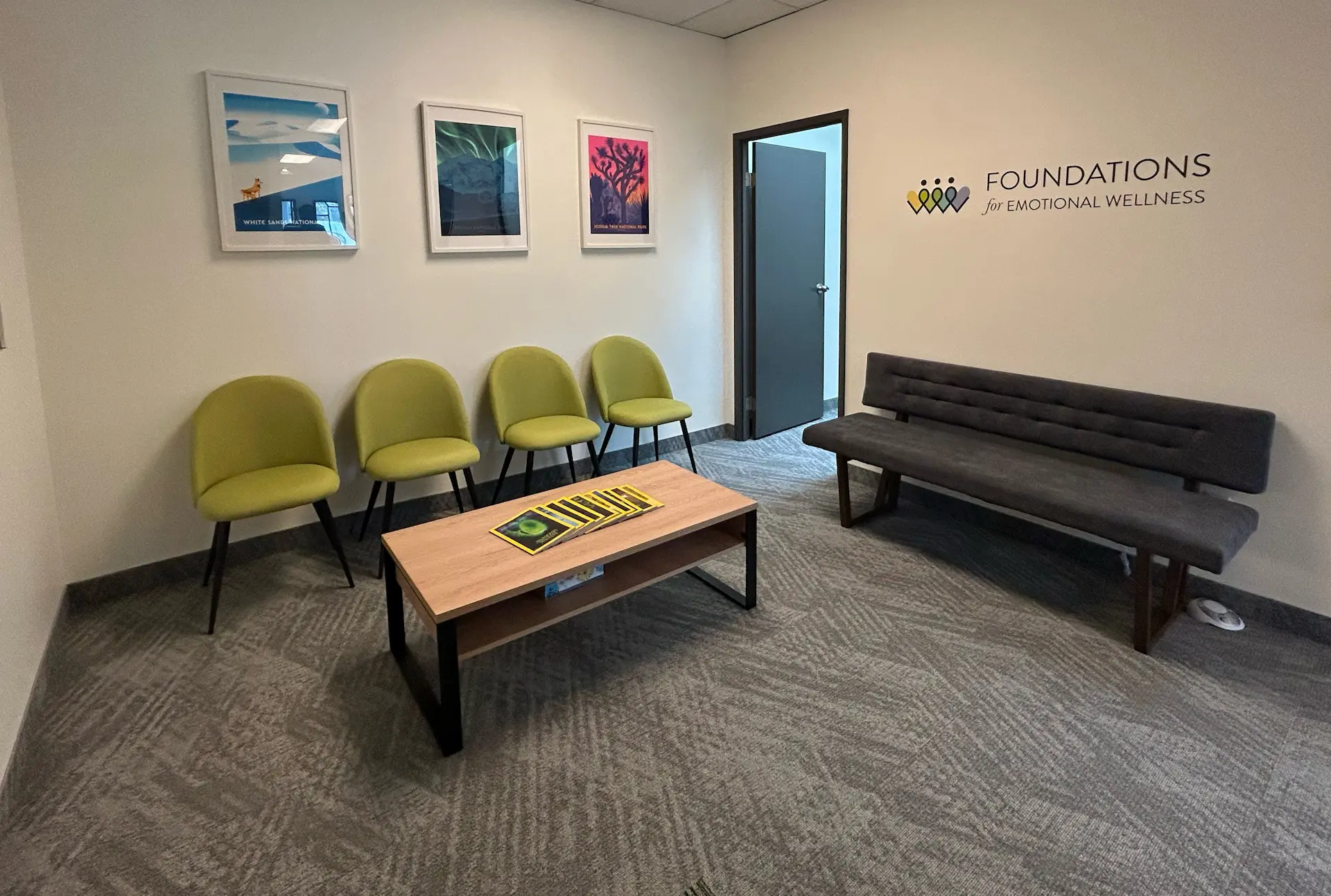 Waiting room at the Foundations for Emotional Wellness Riverdale office, with green chairs, a bench and the clinic logo on the wall