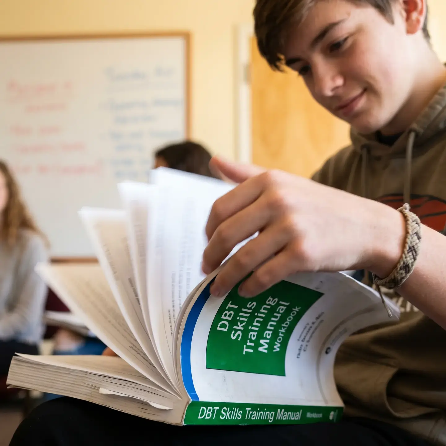 Teen reviewing DBT manual